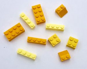 A pile of yellow LEGO bricks of subtlety different shades